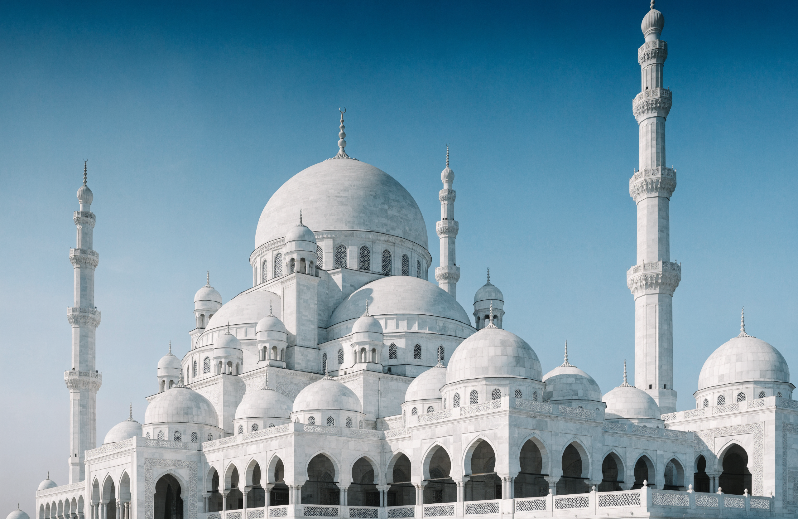 White marble mosque against a blue sky